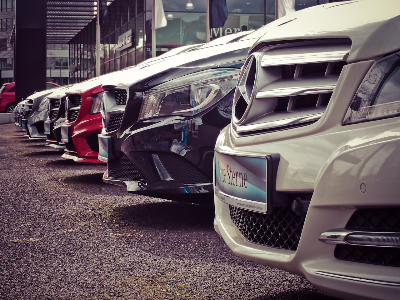 services-03 Luxury cars lined up at an outdoor dealership, showcasing sleek designs.