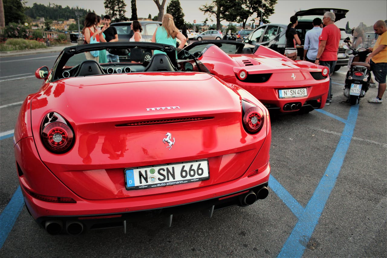 services-01 A pair of red Ferrari cars parked outdoors in Firenze, Italy, showcasing luxury automotive design.